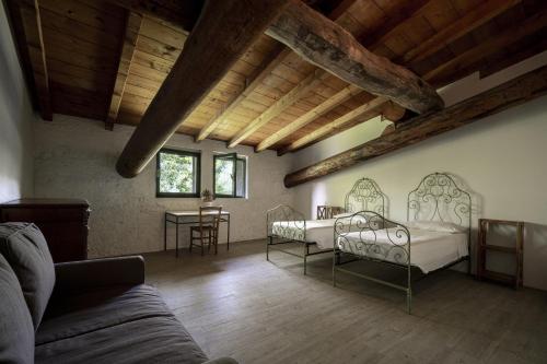Sala de estar con 2 camas y mesa en Agriturismo Le Chiusure, en San Felice del Benaco