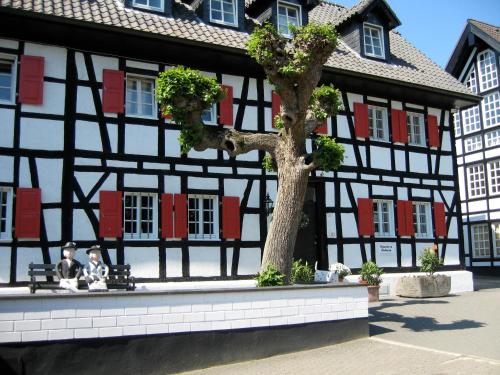 two people sitting on a bench in front of a building at Haus Dürresbach in Hennef