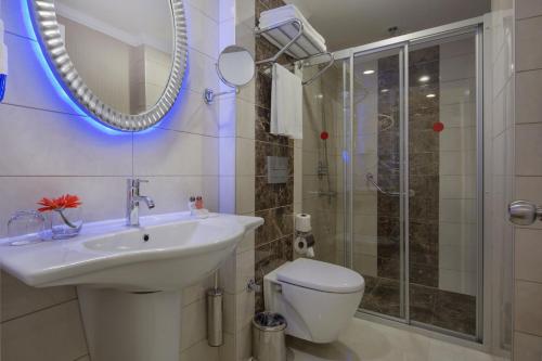 uma casa de banho com um lavatório, um WC e um espelho. em Alaiye Kleopatra Hotel em Alanya