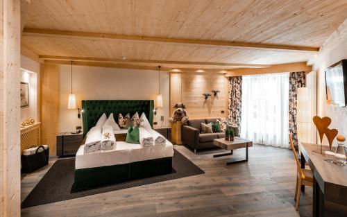 カステルロットにあるAlpin Boutique Villa Gabriela - Adults Onlyのベッドとソファ付きの広い客室です。