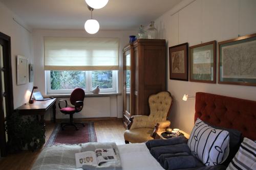 a living room with a bed and a desk and a window at Studio Dom Nałęczowski in Nałęczów