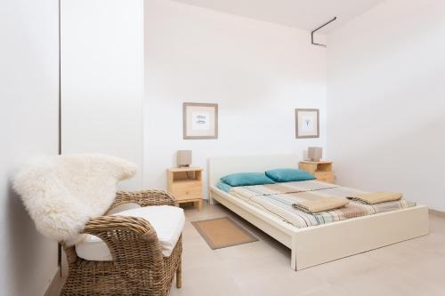 una camera con letto e sedia in vimini di Modern House With Private Swimming Pool a El Médano
