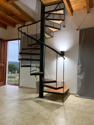a spiral staircase in a room with a wall at Posada La Candelaria in Cosquín