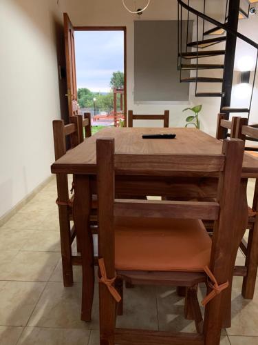 a wooden dining room table and chairs with a window at Posada La Candelaria in Cosquín