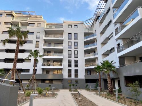 un condominio con palme di fronte di T2 Ajaccio vue mer ad Ajaccio
