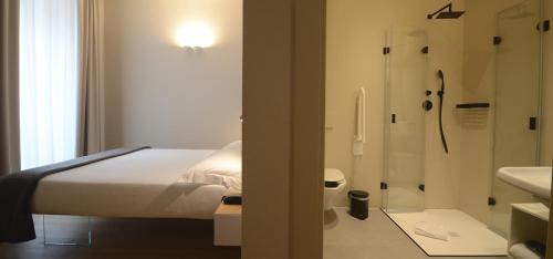 a bedroom with a bed and a shower and a bathroom at Albergo Centrale in Lamezia Terme