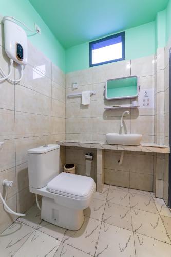 a bathroom with a toilet and a sink at Olhumathi View Inn in Ukulhas