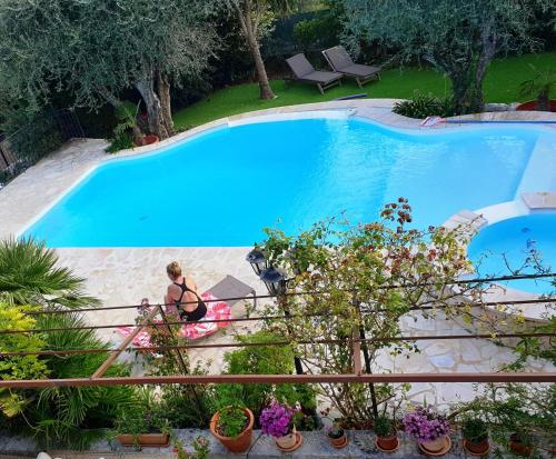 a woman sitting on the stairs next to a swimming pool at Villa Mia in Vence