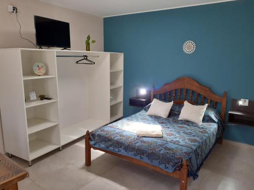1 dormitorio con 1 cama, TV y estanterías en Departamento 4 Complejo Sol de Oeste, en San Juan