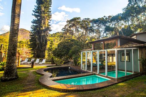 a house with a swimming pool in a yard at Villa Don in Petrópolis
