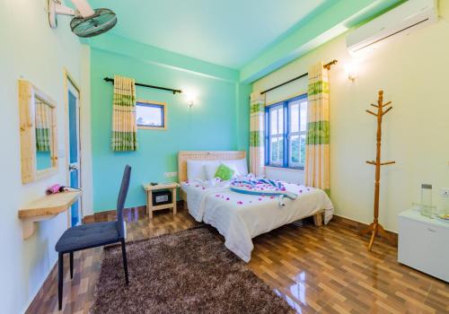 a bedroom with a bed with blue walls and wooden floors at Olhumathi View Inn in Ukulhas