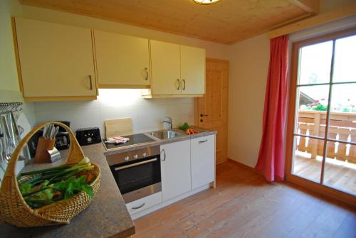 a kitchen with yellow cabinets and a sink and a window at Oberkantiolhof in Villnoss