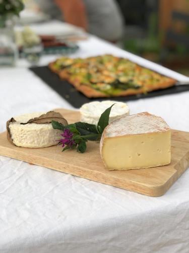 a wooden cutting board with cheese and bread on a table at Rejaillir in Saint-Ours
