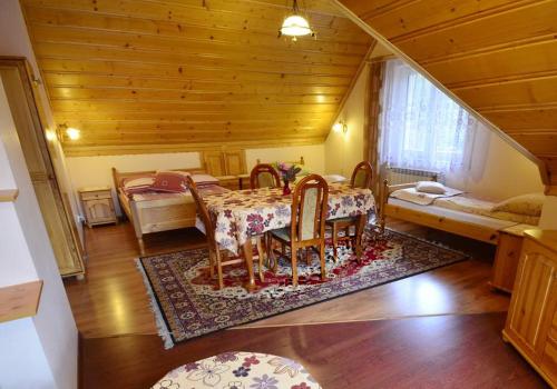 a dining room with a table and chairs in a room at Willa Modrysówka in Zawoja