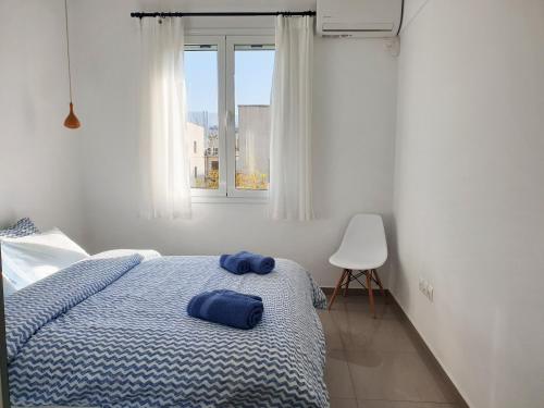 a bedroom with a bed with blue sheets and a window at KYMA Apartments - Athens Acropolis 7 in Athens