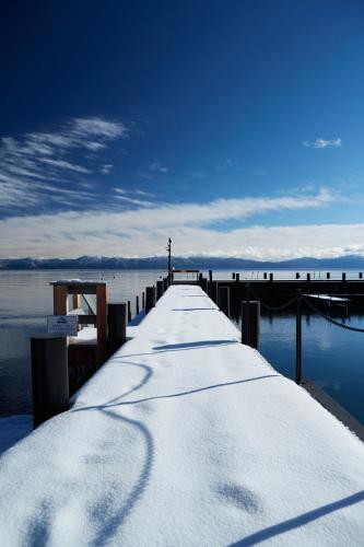 a pier with snow on it next to the water at Sunnyside Resort and Lodge in Tahoe City