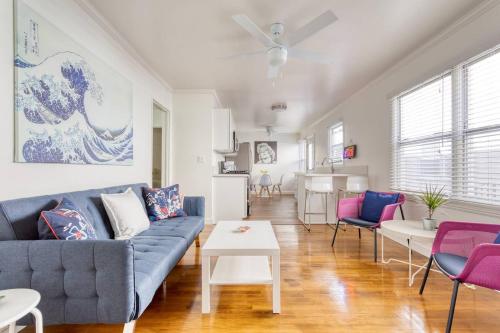 a living room with a blue couch and purple chairs at New Beach Jewel Bungalow in Long Beach