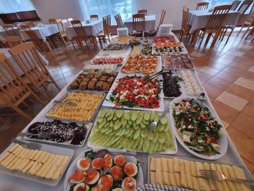un lungo tavolo pieno di diversi tipi di cibo di Tasarz Spa Ośrodek Wczasowy a Rewal