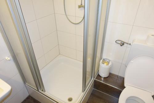 a shower stall in a bathroom with a toilet at Gasthof & Restaurant "Am Kreuz" in Essen