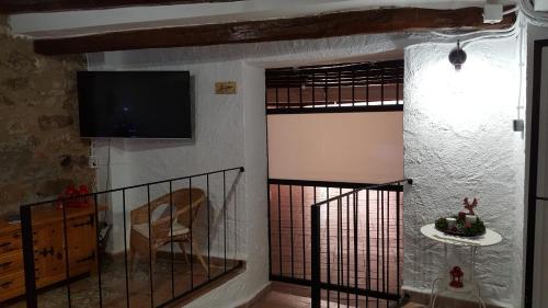 a room with a door with a television and a chair at espai Abadia in Argentera