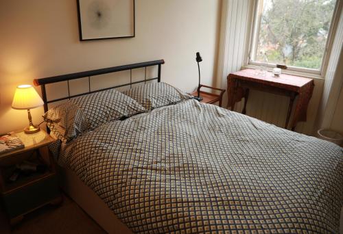 a bedroom with a bed and a window and a lamp at Woodburn Terrace, Morningside, Edinburgh in Edinburgh