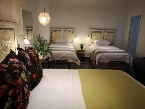 a hotel room with two beds and a couch at INBLOEM in Bloemfontein