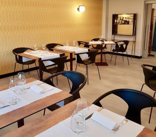 um restaurante com mesas e cadeiras com copos de vinho em Cravero Rooms em Caltignaga