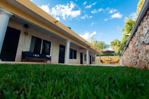 a house with a green lawn in front of it at Nicol-Haa in Izamal