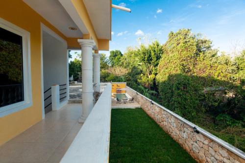 a patio of a house with a retaining wall and grass at Nicol-Haa in Izamal