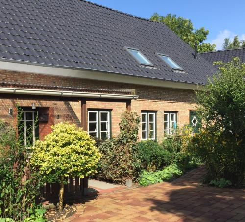 a red brick house with a black roof at SchönErleben in Schwabstedt