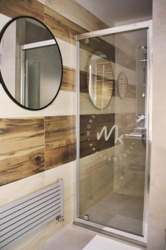 a bathroom with a mirror and a shower at Morska Kryjówka in Niechorze