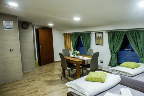 a room with two beds and a table and chairs at Villa Zoki - soba dnevni najam in Zagreb