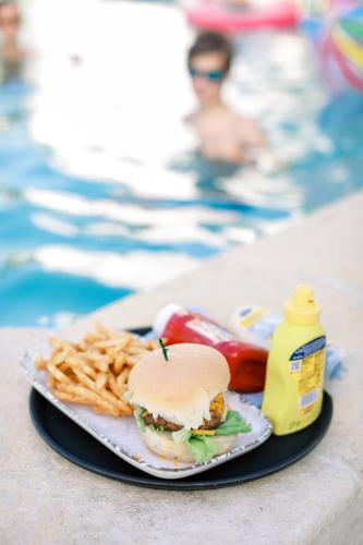 a plate with a sandwich and french fries and a bottle of mustard at Sand Castle on the Beach - Adults Only in Frederiksted