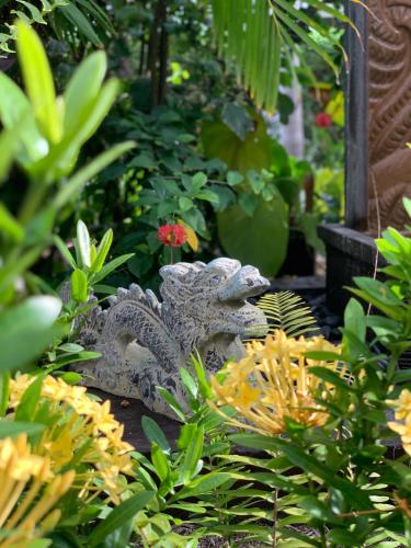 a statue in a garden with flowers and plants at Sand Castle on the Beach - Adults Only in Frederiksted