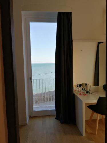 a door to a balcony with a view of the ocean at B&B VISTAZZURRA - Casa Saldarelli in Giovinazzo