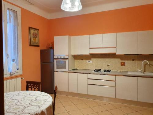 a kitchen with white cabinets and a black refrigerator at Liluna in Bologna