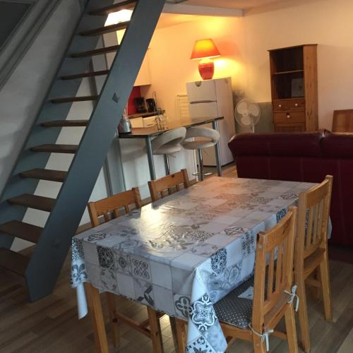 une salle à manger et une cuisine avec une table et un escalier dans l'établissement les magnolias, à Colmar