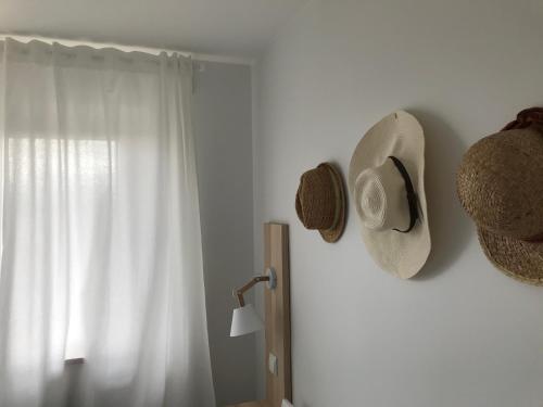 a hat hanging on a wall next to a window at Morska Kryjówka in Niechorze