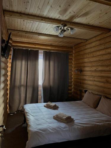 a bedroom with a bed with two towels on it at Шервуд in Myta