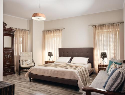 1 dormitorio con 1 cama grande y 1 sofá en Joya Village House, en Agios Leon