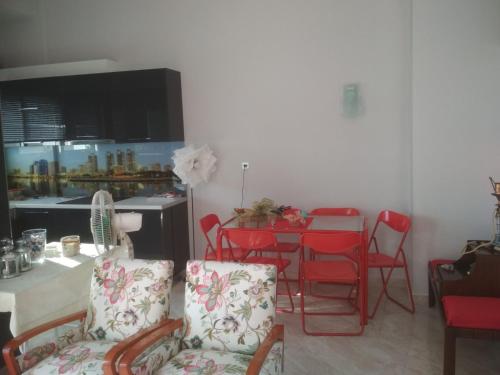 un soggiorno con tavolo e sedie rosse di PARaDiSo a Ormos Panagias