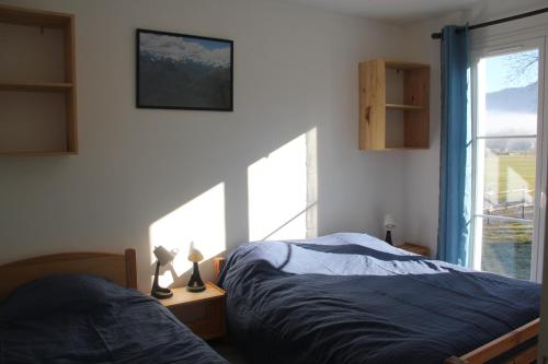 a bedroom with two beds and a large window at Gite l'Estibère en Val d'Azun in Aucun