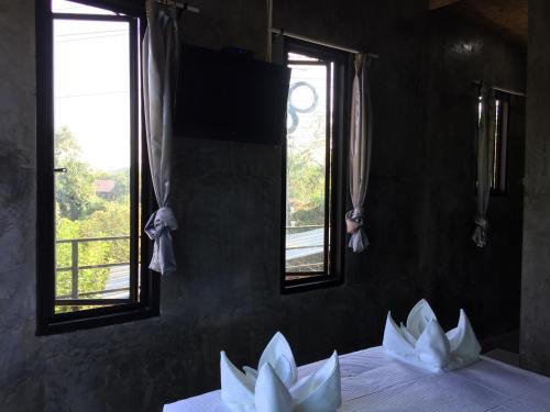a room with three windows and two white paper flowers at ชลลดา ริเวอร์ โฮมสเตย์ แก่งกระจาน in Ban Wang Malako