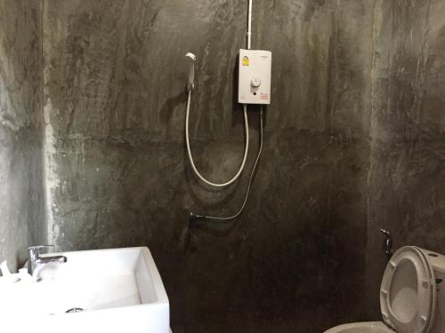 a shower in a bathroom with a sink and a toilet at ชลลดา ริเวอร์ โฮมสเตย์ แก่งกระจาน in Ban Wang Malako