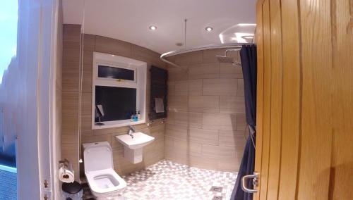a bathroom with a toilet and a sink at Canyon Cottage in Pont-Nedd-Fechan