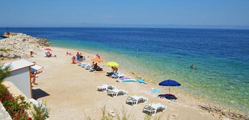 a group of people on a beach with umbrellas at Apartment with Sea View in Prigradica