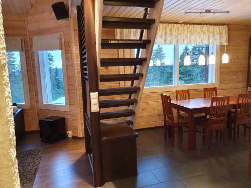 a spiral staircase in a dining room with a table at Hietavilla Aurora in Ruka