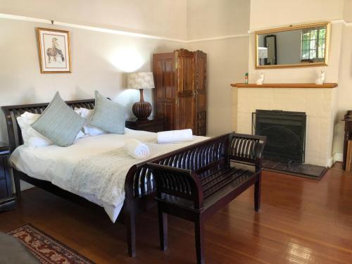 a bedroom with a large bed and a fireplace at The Solomon Guest House in Kimberley