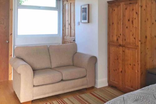 a living room with a couch and a window at Modern Studio Apartment Near Town Centre in Poole