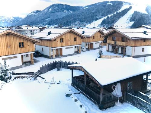 a village covered in snow with mountains in the background at Sieglhub Chalets - Appartements - Hotel in Flachau